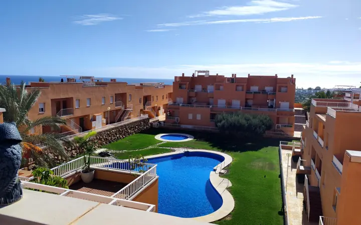 Piscina comunitaria con el mar al fondo